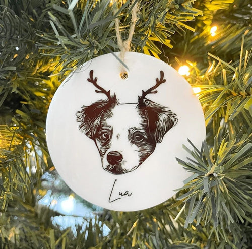 Close-up of a ceramic pet ornament showing the printed dog portrait and the personalized name Lua